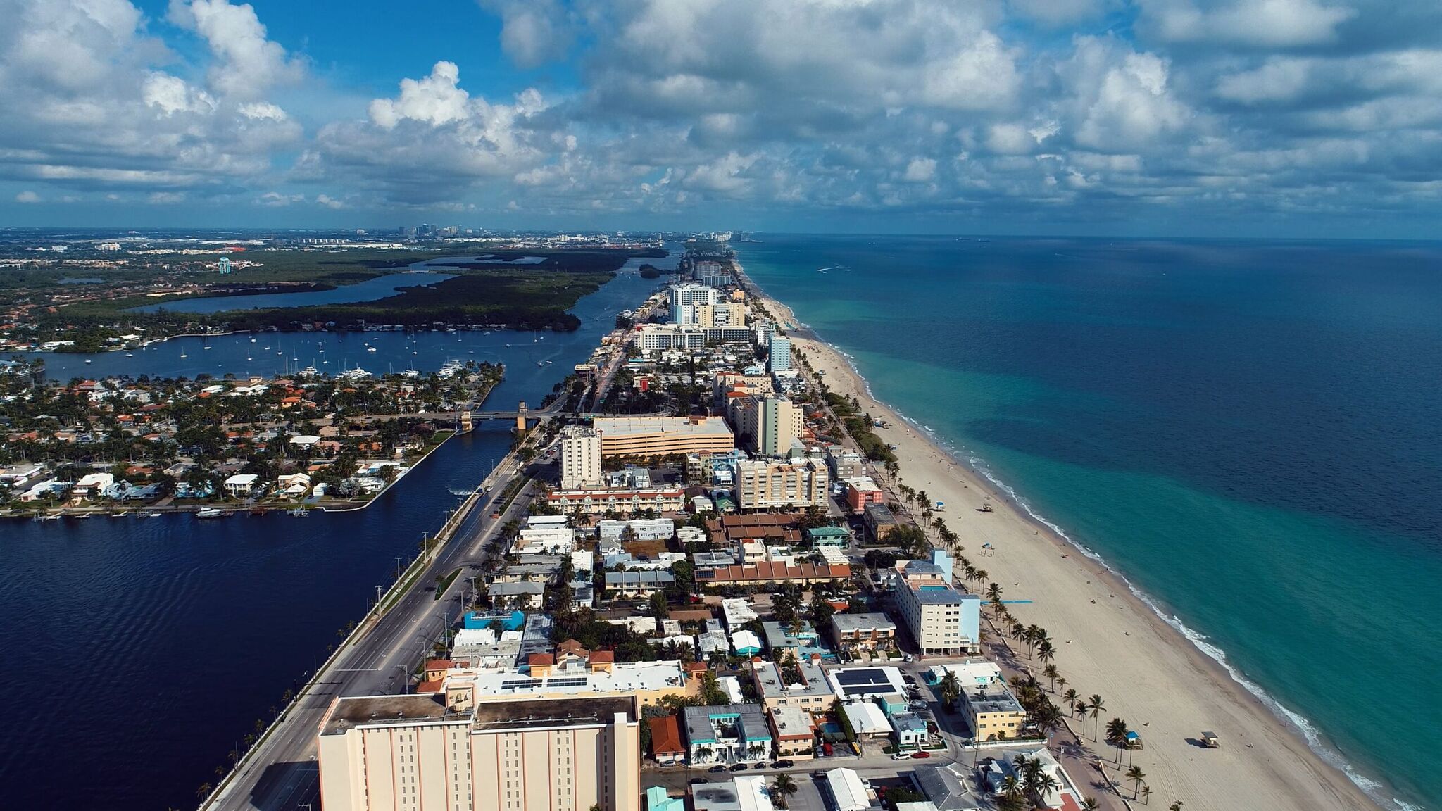 Aerial view of Hollywood Beach, Florida, looking north along the Atlantic shoreline toward Fort Lauderdale, with the Intracoastal Waterway and marina to the west.